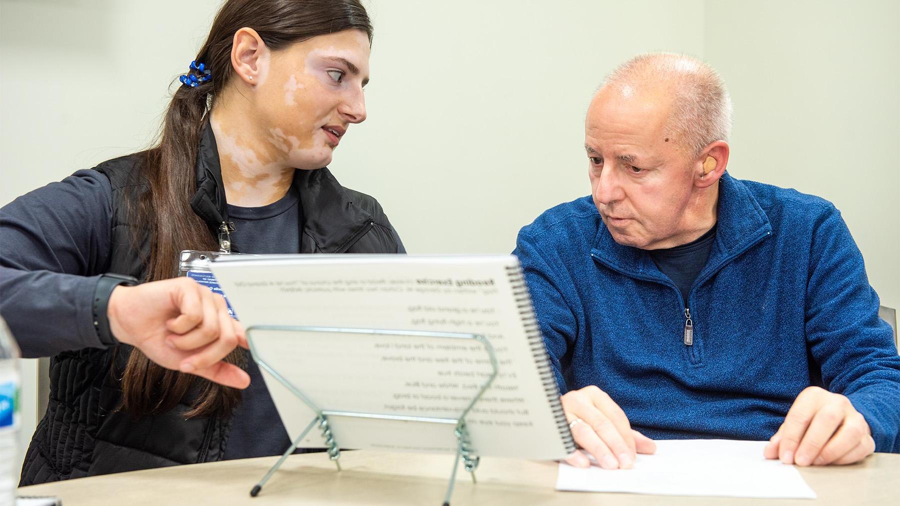 Student working at the Speech Language Pathology Clinic with an elderly patient.